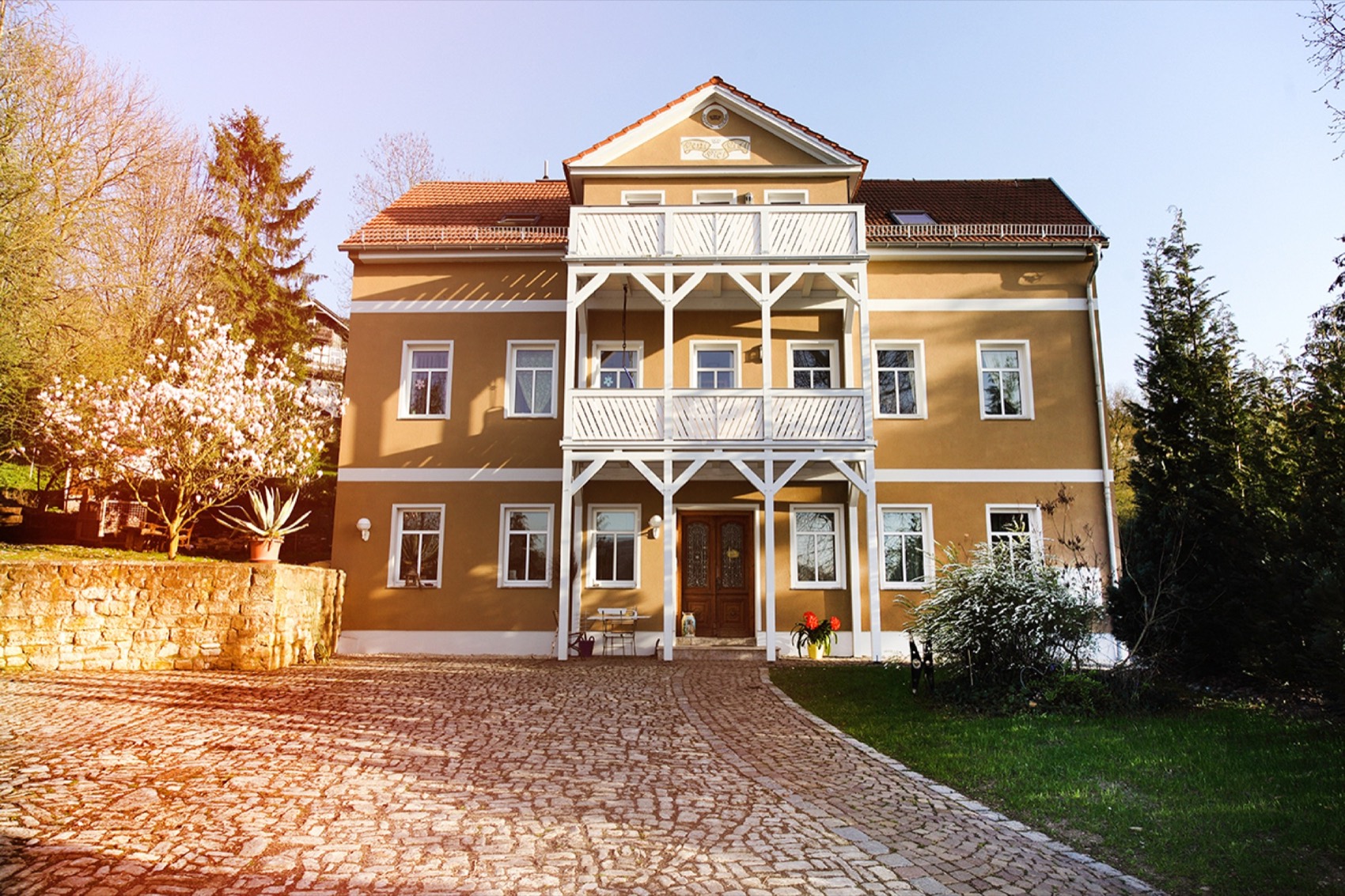 Das Haus der Familie Brauer in Bad Sulza im Abendlicht, mit blühender Magnolie und gepflastertem Hof