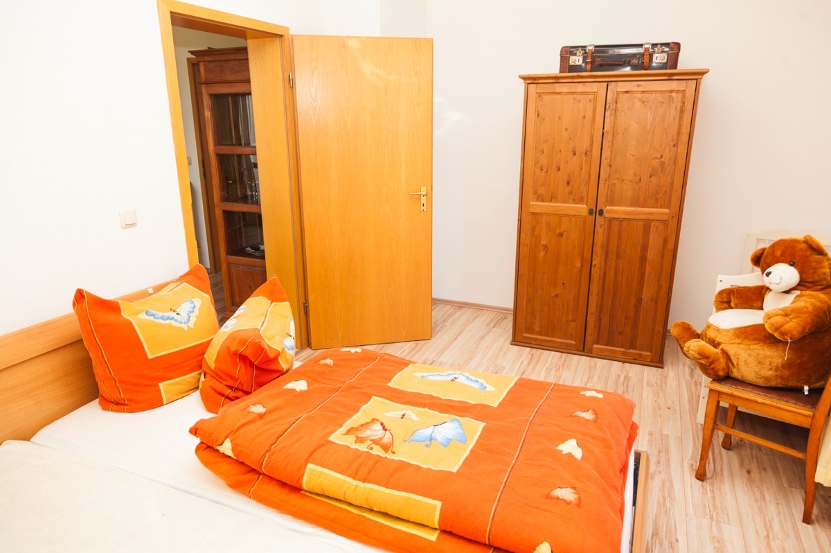 Schlafraum der Wohnung 2 mit Bett und Kleiderschrank